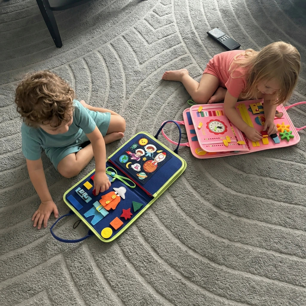 Due bambini giocano sul tappeto di casa con le valigette Manine blu e rosa