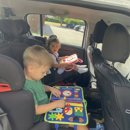 Due bambini giocano con le valigette Manine sul sedile posteriore dell'auto